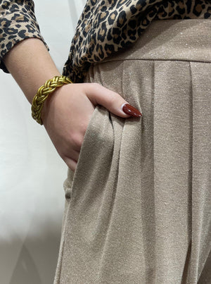 Pantalon paillette beige Momoni de chez Charlotte Avignon en close up avec des mains colorés rouges.